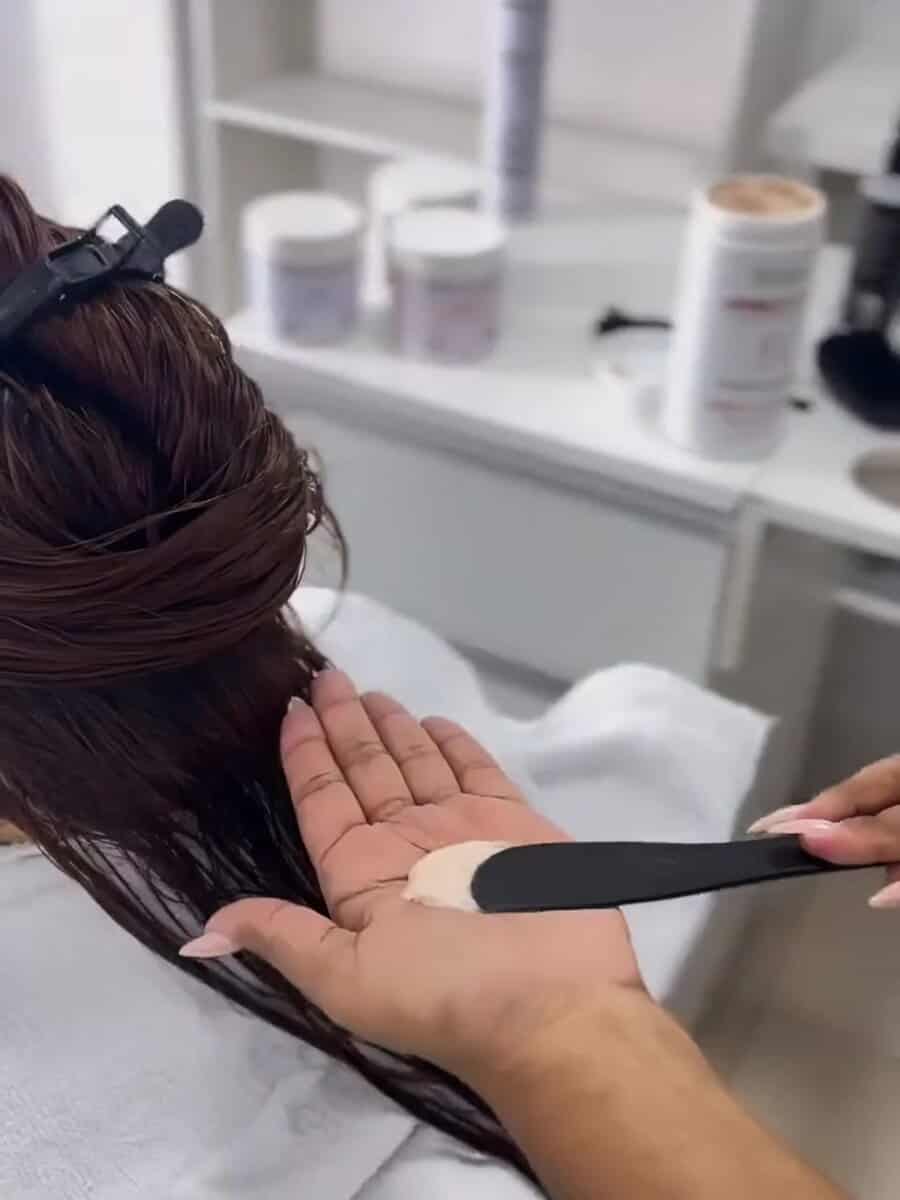 Profissional preparando máscara de reconstrução para aplicação durante o cronograma capilar no Ateliê SF Beauty.
