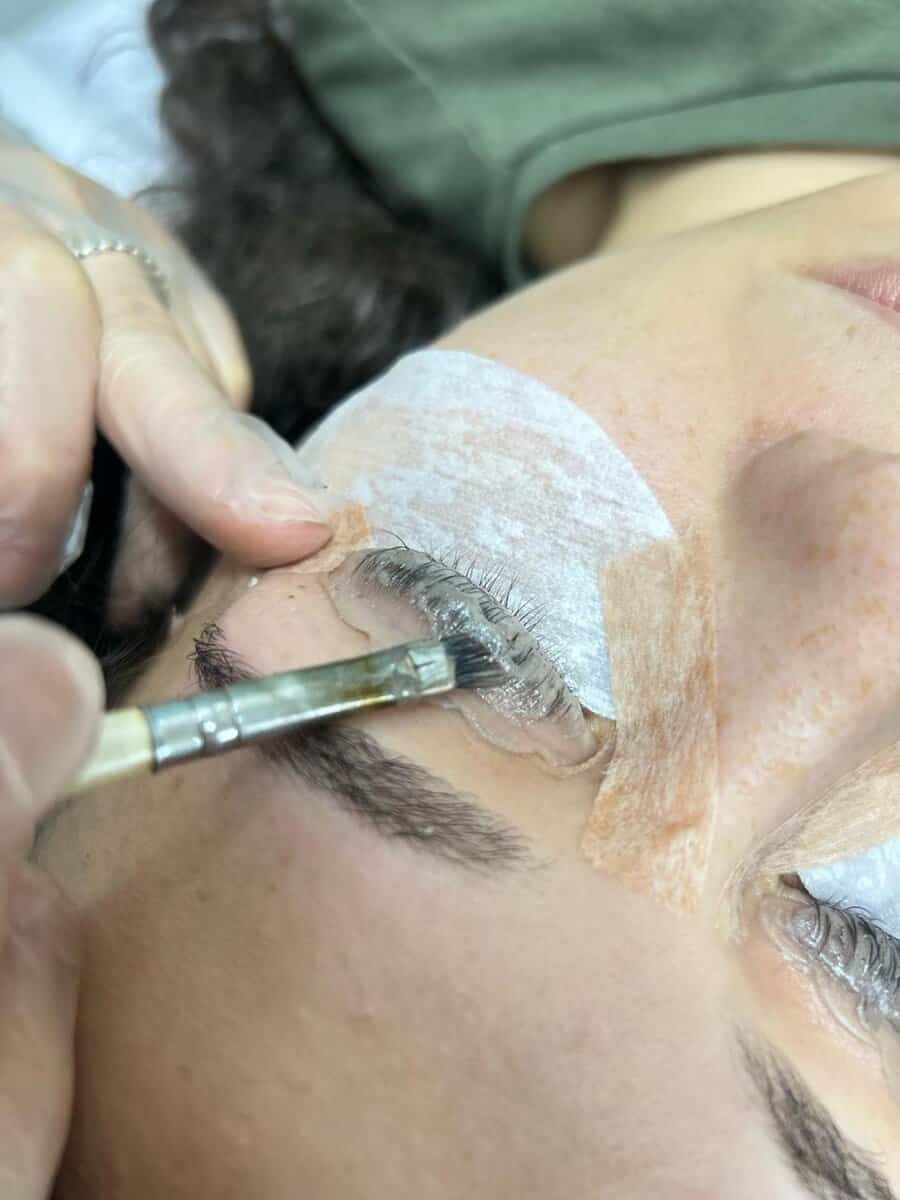 Profissional aplicando produto nutritivo durante o procedimento de lash lifting no Ateliê SF Beauty.