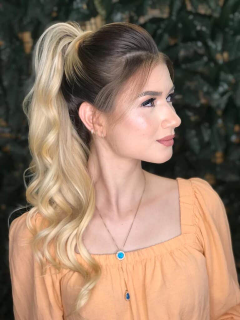 Penteado de festa com rabo de cavalo alto e ondas modeladas, serviço de cabelo profissional em Governador Valadares.