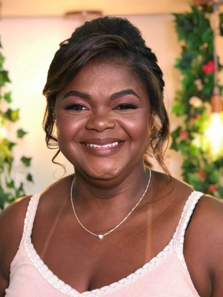 Linda mulher sorrindo após tratamento de beleza no Ateliê SF Beauty com maquiagem e penteado profissionais.