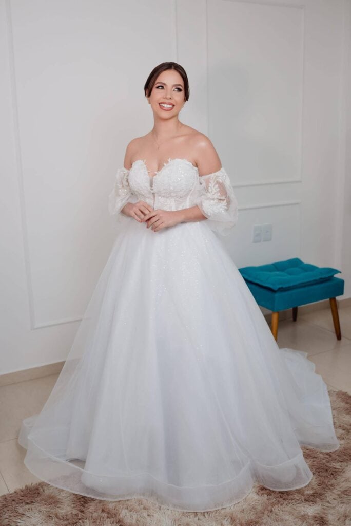 Elegante vestido de noiva com detalhes em renda e saia longa, ideal para casamentos sofisticados, em clima romântico, perfeito para ensaio de vestido de casamento.