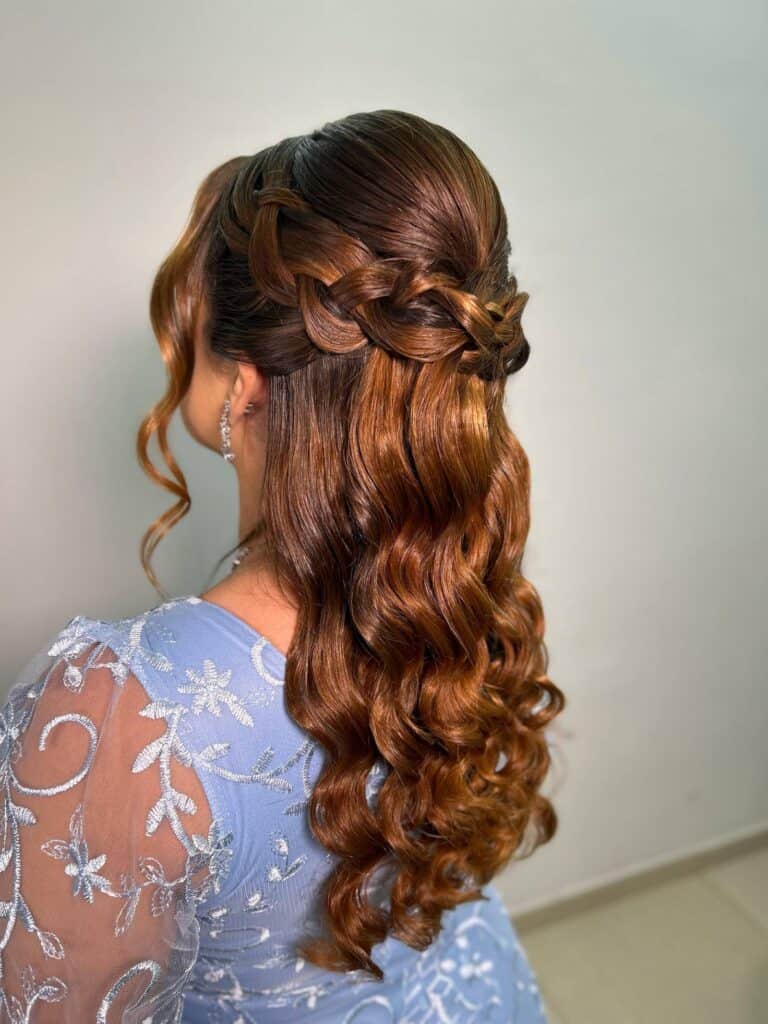 Cabelo com penteado de trança e cachos em tom castanho avermelhado, ideal para eventos especiais.