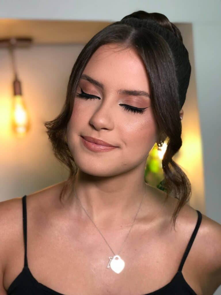 Beleza, rosto de mulher com maquiagem e cabelo arrumado em ambiente interno.